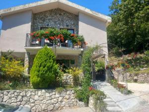 a house with a balcony with flowers on it at Dado in Virpazar