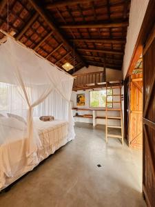 a bedroom with a bed with a mosquito net at Casa da Mata Corumbau in Corumbau