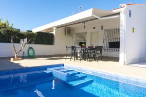 basen ze stołem i krzesłami obok domu w obiekcie CASA SOLEADA Piscina CLIMATIZADA y PRIVADA w mieście Santiago de la Ribera