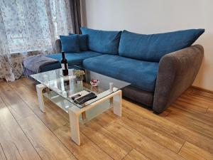 a living room with a blue couch and a table at Brand new apartment with free parking near city center in Sofia