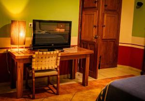 a room with a desk with a television on it at Hotel Boutique Casa San Angel in Mérida