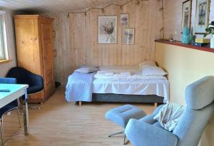 a bedroom with a bed and two chairs in it at Stranda apartment in Stranda