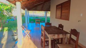 a dining room with a wooden table and chairs at Chácara do Cardoso in Três Marias