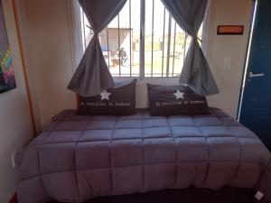 a bed in a room with a window at Portal del Sol in Villa Yacanto