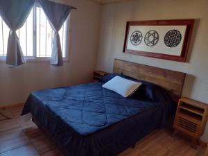 a bedroom with a blue bed in a room at Portal del Sol in Villa Yacanto