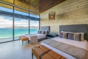 a bedroom with two beds and a view of the ocean at Beachfront house in Kupuri Punta Mita in Puerto Vallarta +94 photos