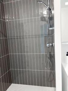 a shower in a bathroom with gray tiles at Studio in Lormont with Free Parking in Lormont