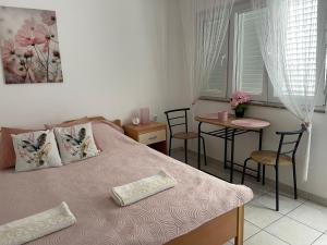 a bedroom with a bed and a table and chairs at Rab Island Apartmets - Palit in Rab