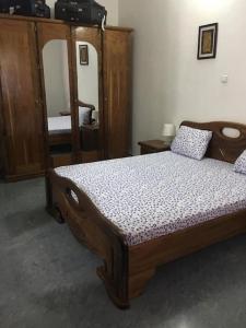 a bedroom with a wooden bed and a mirror at Grand studio climatisé 5' mer accès Dakar in Dakar
