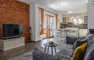 Una sala de estar con un sofá y un televisor. en Stunning Home In Vrsi With Sauna, en Vrsi