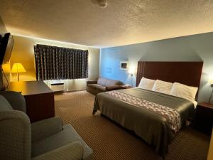 a hotel room with a bed and a couch at Western Inn in Council Bluffs