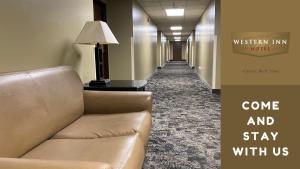 a hallway with a couch and a lamp in a hotel at Western Inn in Council Bluffs