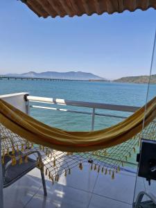 eine Hängematte auf der Rückseite eines Bootes auf dem Wasser in der Unterkunft Casa no Mar de Junqueira in Mangaratiba
