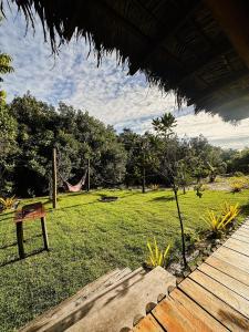 a hammock in a field with a hammock at Casa da Mata Corumbau in Corumbau