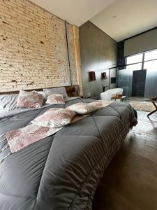 two beds in a room with a brick wall at Vinícola Mirantus in Espirito Santo Do Pinhal