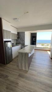 cocina grande con encimera y nevera en Apartamento frente a la playa de la guaira, en San Julián