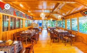 a dining room with tables and chairs and windows at Stone Garden Resort & Spa in Sa Pa