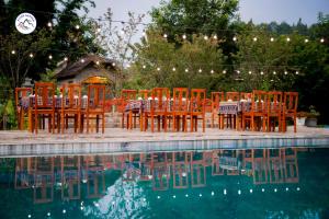 a group of tables and chairs next to a pool at Stone Garden Resort & Spa in Sa Pa