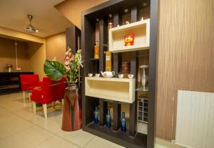 a living room with a red chair and a shelf with vases at Sun Inns Skudai in Skudai
