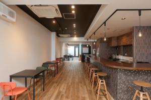 a restaurant with a bar with tables and chairs at 会津七日町inn in Aizuwakamatsu