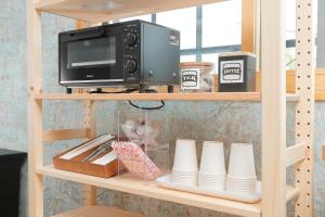 a book shelf with a tv and a microwave at 会津七日町inn in Aizuwakamatsu