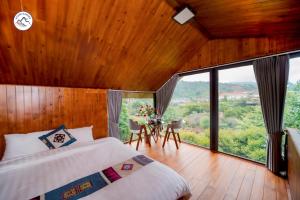 a bedroom with a bed and a large window at Stone Garden Resort & Spa in Sa Pa +38 photos