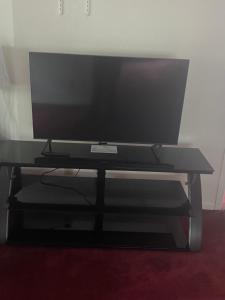 a flat screen tv sitting on a black tv stand at Apartamento en Milwaukee cerca del centro 8 mins from Milwaukee downtown in Milwaukee