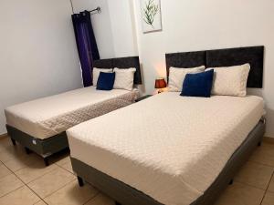 2 letti in una camera con cuscini blu di Apartamentos Trebol a Comayagua