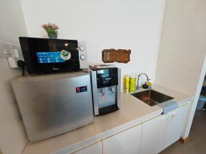a kitchen with a refrigerator and a tv on top of it at Kuantan City 188 in Kuantan