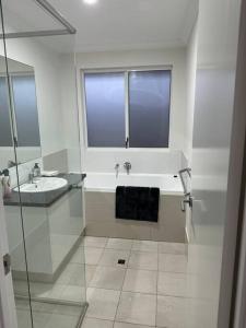 un bagno bianco con lavandino e doccia di Golfers dream 300m to the beach a Dawesville Altre 14 foto