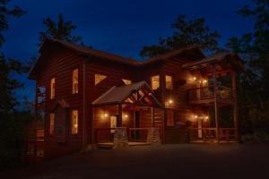 ガトリンバーグにあるCopper Creek Lodgeの夜間のバルコニー付きのログキャビン