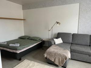 a living room with a bed and a couch at Apartment Kopin3 in Kokkola