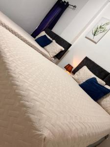 un letto bianco in una stanza con cuscini blu di Apartamentos Trebol a Comayagua