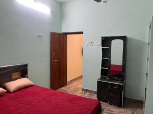 a bedroom with a red bed and a mirror at KR homestay in Tiruvannāmalai