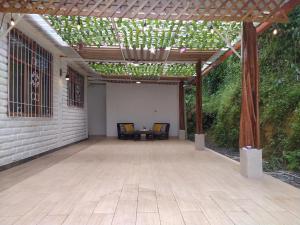 a pergola with two chairs and a table on a patio at Casa VIP II in Puyo