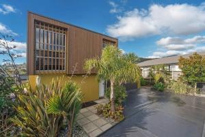 a yellow building with plants in front of it at Tahuna Beach Oasis in Nelson