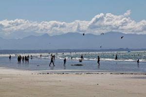 a group of people standing in the water at the beach at Tahuna Beach Oasis in Nelson