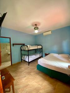 a bedroom with a bed and a bathroom with a shower at Hotel Paraíso del Sur in San Juan del Sur