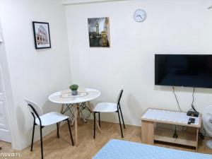a living room with a table and chairs and a tv at Sanremo Oasis by Beau Condotels in Cebu City