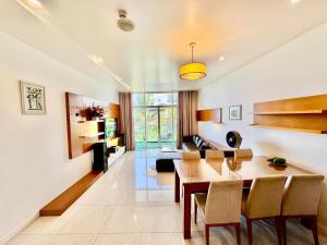 a dining room and living room with a table and chairs at By The Beach Apartment in Ấp Ngọc Hải