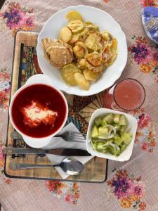 a table with two plates of food and a bowl of sauce at Будиночок Мойсейчуків in Krivorovnya +21 photos