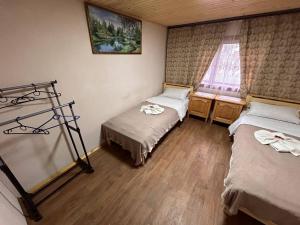 a room with two beds and a window at Будиночок Мойсейчуків in Krivorovnya