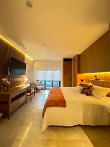 a hotel room with a large bed and a desk at Zantamar La Cruz Beach & Pool in Cruz de Huanacaxtle +3 photos
