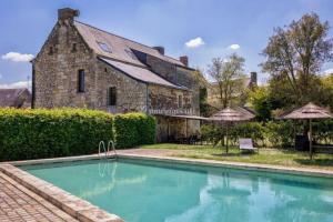 a house with a swimming pool in front of a building at Domaine du prieuré Saint Ellier in  Charcé-Saint-Ellier-sur-Aubance