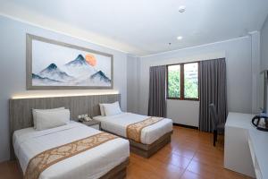Uma cama ou camas num quarto em Front One HK Resort Simpang Lima