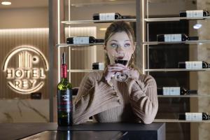 a woman sitting at a table with a glass of wine at Hotel Rey in Huancayo