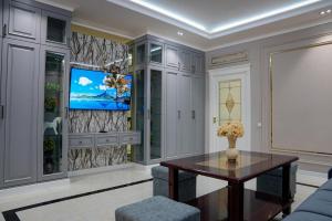 a living room with a tv and a table at Learmara Apartment #2 in Samarkand