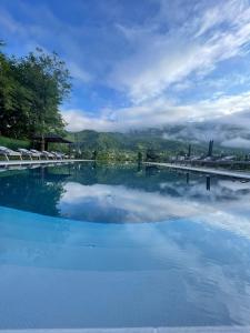 a large pool of water with a bridge in the background at ციბენა • Tsibena in Ambrolauri