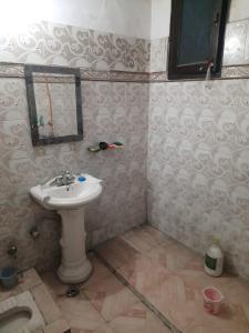 un baño con lavabo y espejo en Guest house, en Ghaziabad