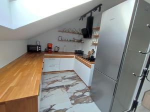 a kitchen with a marble floor and a refrigerator at U Tofika in Grzechynia
